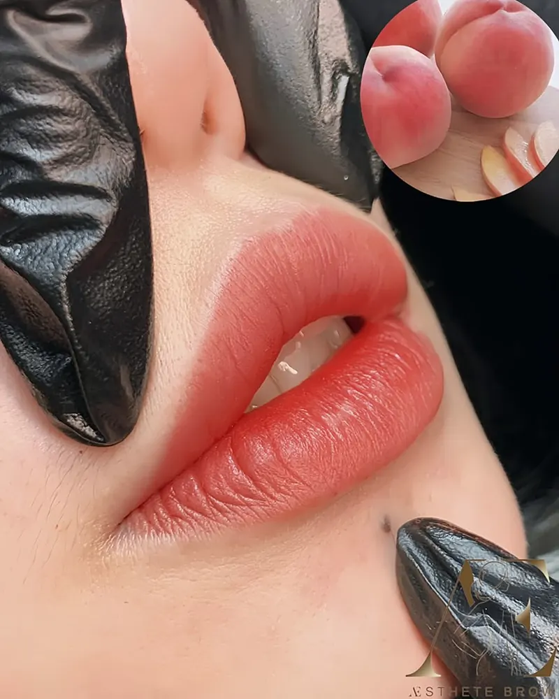 Lips in a peach shade after lip blush, shown beside fresh peaches